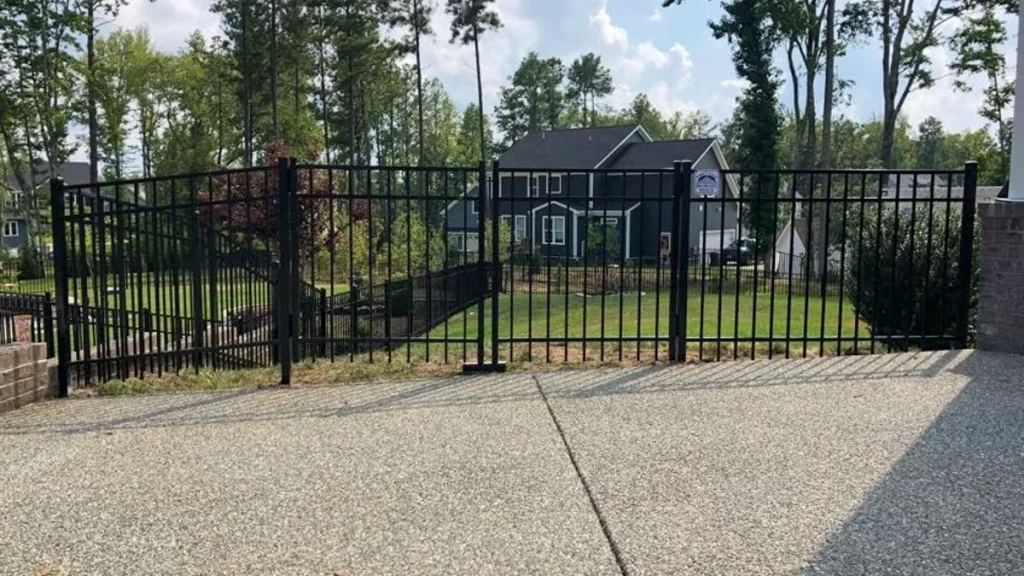 A black residential aluminum fence with a security gate. First Step Fence aluminum fences provide enhanced security.