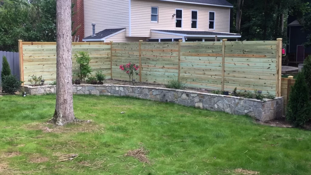 A modern wood fence with eco-friendly materials enhancing a landscaped yard. First Step Fence provides sustainable wood fencing options.