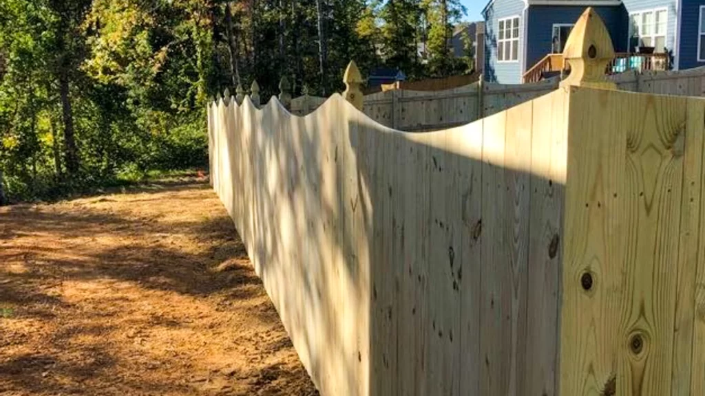 A tall wood privacy fence with decorative finials, enhancing privacy and security. First Step Fence ensures durable and secure wood fencing solutions.