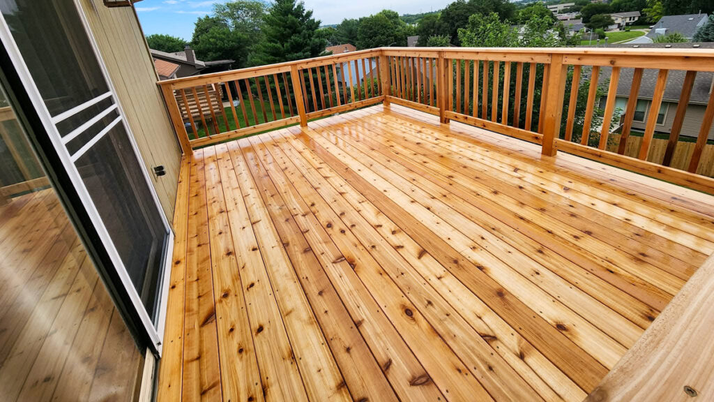 A newly built wood deck with natural wood tones, featuring a stunning open view. First Step Fence creates wood decks that enhance your home's natural beauty.