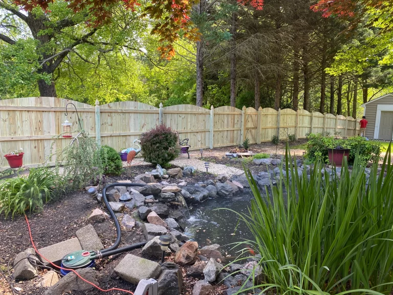 A photograph of a backyard surrounded by a wood privacy fence.