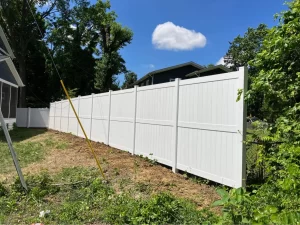 A photograph of a white vinyl privacy fence.