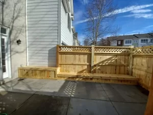 Wood bench seating connected to a custom wood fence for additional patio seating.