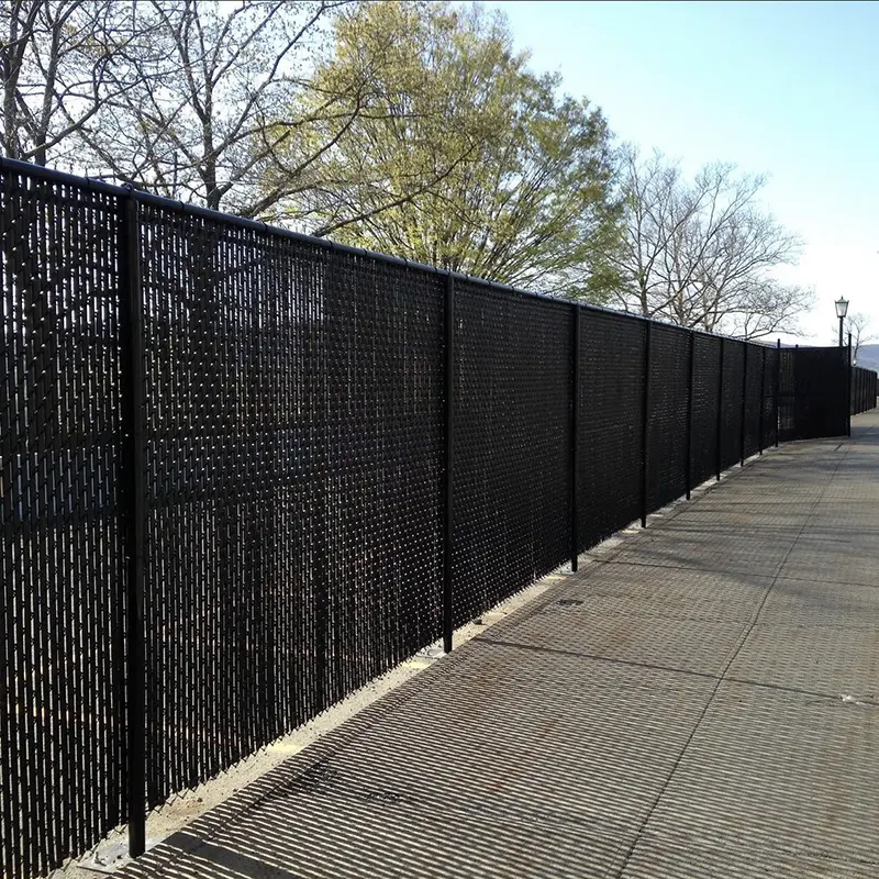 A tall, vinyl coated chain link fence with privacy slats. First Step Fence installs privacy slats in chain link fences for residential and commercial properties in Richmond, VA and the surrounding areas.