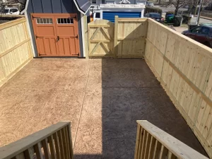 A photograph of a patio surrounded by a wood privacy fence.