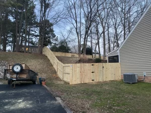 A wood privacy fence built on a very sloped yard and up a hill.