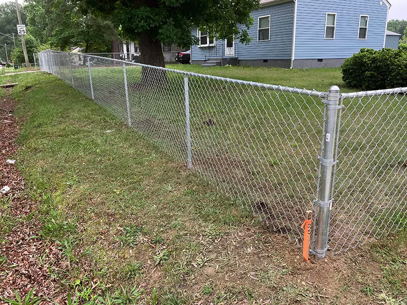 A standard chain link fence on the perimeter of a residential property. First Step Fence offers standard chain link fencing to Richmond, VA and the surrounding area.