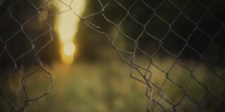 A photo of a broken chain link fence. First Step Fence repairs fences in Richmond, VA and the local area.